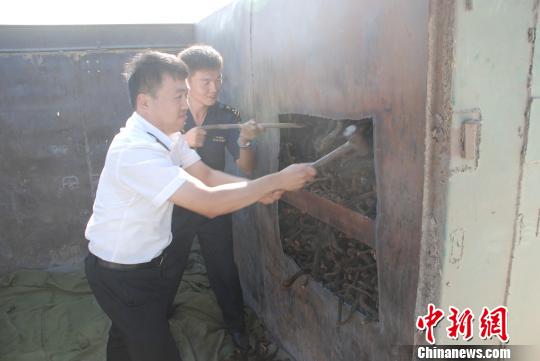 圖為現(xiàn)場(chǎng)關(guān)員卸去車?yán)飱A層內(nèi)的走私物品。　呼和浩特海關(guān)提供　攝